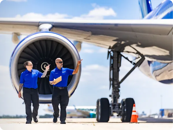 Two workers beside an airplane